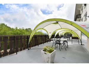 a green and white canopy on a balcony with tables and chairs at Hotel Takimoto - Vacation STAY 43487v in Yamanouchi