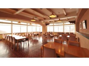 a dining room with tables and chairs and windows at Hotel Takimoto - Vacation STAY 43492v in Yamanouchi