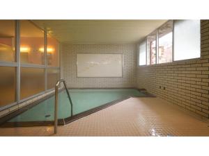 a swimming pool in a room with a brick wall at Hotel Takimoto - Vacation STAY 43488v in Yamanouchi