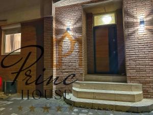 a brick building with a blue door and stairs at Princ house in Leskovac
