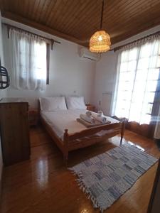 a bedroom with a bed with a rug and windows at Seaside Selana Home in Nikiana