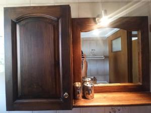 a person taking a picture of a bathroom mirror at Seaside Selana Home in Nikiana +22 photos
