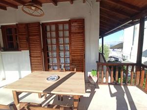 a wooden table on the porch of a house at Seaside Selana Home in Nikiana