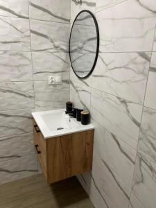 a bathroom with a sink and a mirror at Pokoje na Jaśminowej in Pisz
