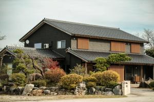 una casa negra con un jardín delante en Shikinoyado Murakami - Vacation STAY 43691v, 