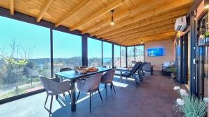木洛希尼的住宿－Kasthouse Luxury mobile home Orange，一间带桌椅和窗户的用餐室