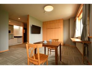 a room with a table and chairs and a kitchen at Hotel Takimoto - Vacation STAY 43491v in Yamanouchi