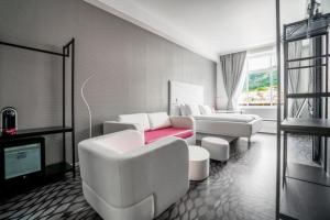 sala de estar con muebles blancos y sofá rojo en Magic Hotel & Apartments Kløverhuset en Bergen