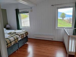 a bedroom with a bed and two windows at Visit Undredal in Undredal