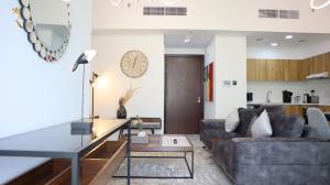 a living room with a couch and a table at Noir Haven Bold 2BR Duplex in Oasis - Chic Retreat Near Masdar Park & City Centre in Abu Dhabi