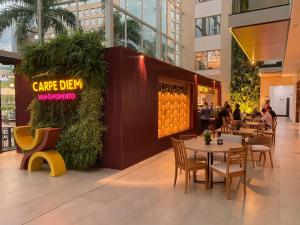 a restaurant with tables and chairs in a building at Atrium Studios by Xtay –Modern, Well-Located Studios, 9min from Arena Opus in Palhoça
