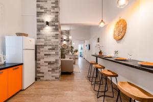 eine Küche mit einer Theke mit Hockern und einem Kühlschrank in der Unterkunft Monastiraki Luxury Loft in Athen