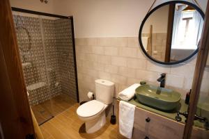 La salle de bains est pourvue de toilettes, d'un lavabo et d'un miroir. dans l'établissement Casa Rural Candelas, à Zahara de la Sierra