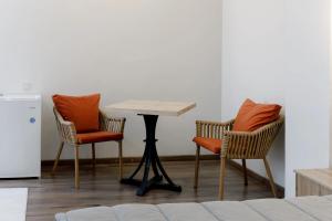 two chairs and a table in a room with a table at Tumar Hansa Ethno Hotel in Astana
