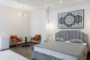 1 dormitorio con 1 cama, mesa y sillas en Tumar Hansa Ethno Hotel en Astaná