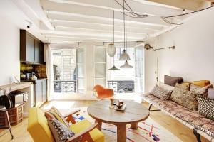 een woonkamer met een bank en een tafel bij Beautiful studio in the heart of the Latin Quarter in Parijs