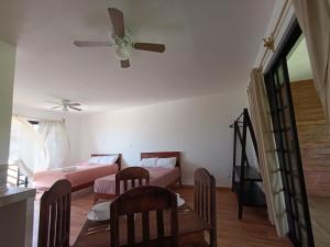 sala de estar con 2 camas y ventilador de techo en Secret Paradise Mahahual, en Mahahual