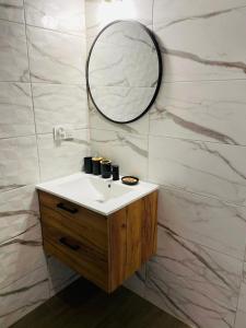 a bathroom with a sink and a mirror at Pokoje na Jaśminowej in Pisz