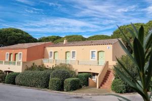een groot huis met groene deuren en struiken bij Chez K&D StudioTerra in Saint-Raphaël