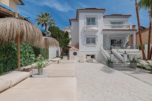 a white house with palm trees and a walkway at VACATION MARBELLA I Sunny Camelia Villa Heated pool in Benalmádena