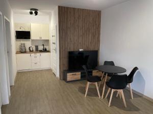 a living room with a table and chairs and a kitchen at Pokoje na Jaśminowej in Pisz