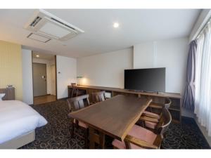 Habitación de hotel con escritorio, TV y cama en Suikoyen Hotel - Vacation STAY 46467v, en Kurume