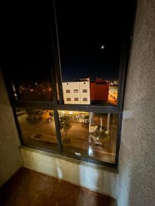 una ventana con vistas a la ciudad por la noche en appartement spacieux en Deroua