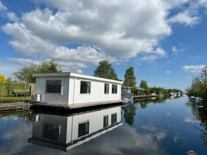 ein Haus auf einem Boot auf einem Kanal in der Unterkunft New- Private Cosy Houseboat, on a lake near Amsterdam in Vinkeveen