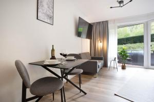 a dining room and living room with a table and chairs at NSV-Apartments am Waldrand in Bad Essen