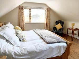 een slaapkamer met een wit bed en een raam bij Mortara Cottage in Ballylongford