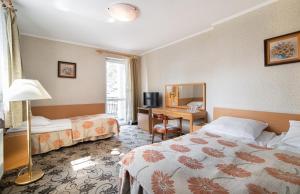 ジブヌベクにあるOśrodek Wczasowy Marevitaのベッド2台とデスクが備わるホテルルームです。