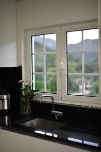 a kitchen with a sink and two windows at CASA RIGOR in Rio Caldo