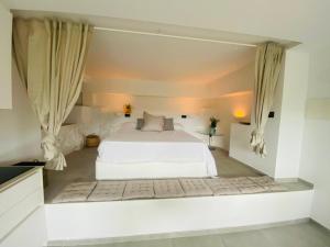 1 dormitorio con cama blanca y cortinas en Pandi's Place, en Sant Pere de Ribes