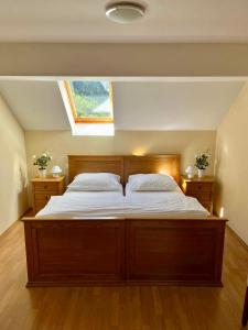 Schlafzimmer mit einem großen Holzbett und einem Fenster in der Unterkunft Hotel Alpine in Log pod Mangartom