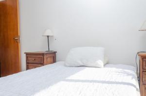 uma cama com uma almofada branca em cima em ¡Tu segundo hogar en Santiago del Estero! Descubrí este pequeño encantador departamento em Santiago del Estero