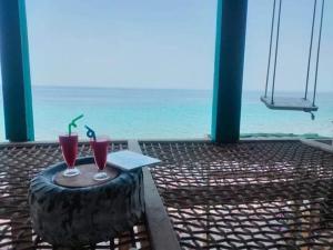 deux verres sur une table avec l'océan en arrière-plan dans l'établissement Downtown pool Bungalows, à Dahab