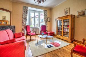 Una sala de estar con sillas rojas y una mesa. en Sweet 38 th, en Périgueux