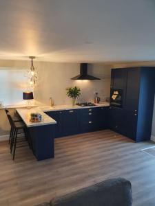 - une cuisine avec des armoires bleues et une table dans une pièce dans l'établissement New 3 bedroom apartment by the beach Belmullet., à Belmullet