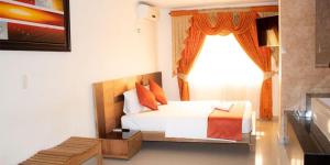 a hotel room with a bed and a window at Hotel el imperio in Quibdó