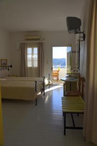 1 dormitorio con cama, ventana y silla en SPITIA VASILI, en Kapsálion