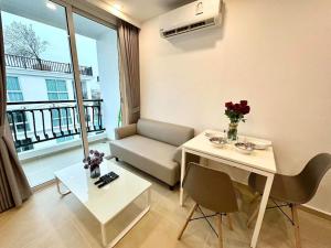 Una sala de estar con un sofá y una mesa con flores. en Free Power&WiFi,Work Remotely, Kitchen,Deal, en Pattaya South