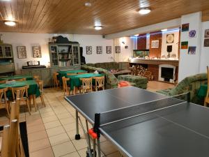 a ping pong table in a room with tables and chairs at Penzion Tesák-ČERŇAVA in Chvalčov