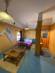 a living room with a bed and a table at Kasbah Of Peace & Boutique in Zagora