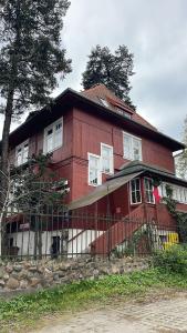 una casa rossa con una recinzione di fronte di Villa Rekin a Danzica