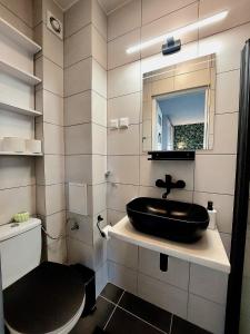 a bathroom with a black sink and a toilet at Zielony Zakątek in Koszalin