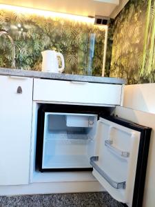 an open refrigerator in a kitchen with a sink at Zielony Zakątek z balkonem in Koszalin