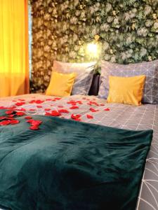 uma cama com rosas vermelhas em cima em Zielony Zakątek em Koszalin