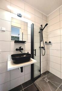 a bathroom with a black sink and a shower at Zielony Zakątek in Koszalin