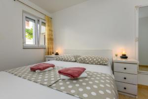 a bedroom with a large white bed with two pillows at Apartments Filipovic in Makarska