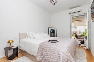 a white bedroom with a bed and a table at A Riduli in Split